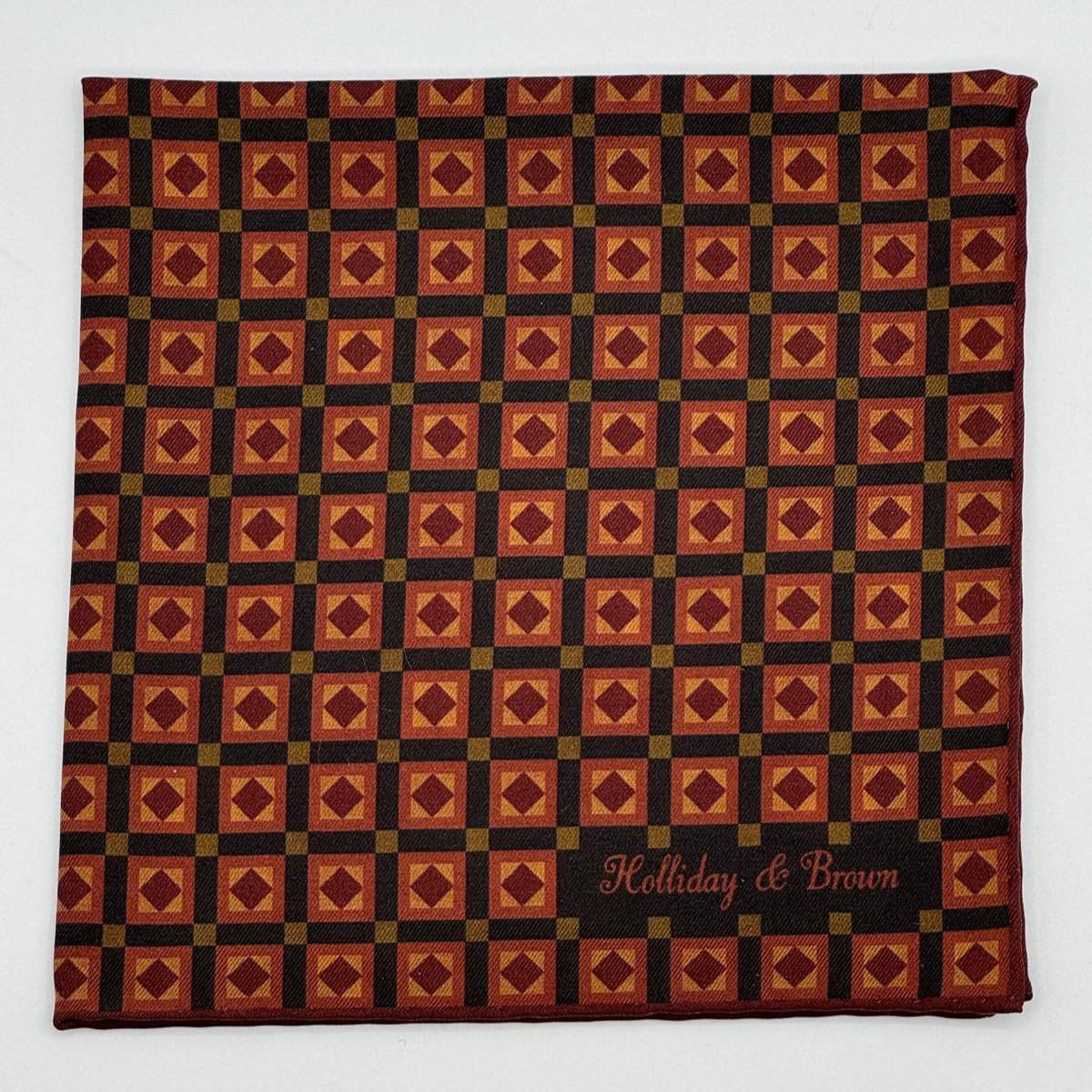 Holliday &amp; Brown for Cruciani &amp; Bella
Hand-rolled&nbsp;&nbsp;

100% Silk
Black, Brown, Red Wine and Gold
Double Faces
Motif&nbsp; Pocket Square
Handmade in Italy

32 cm X 32 cm