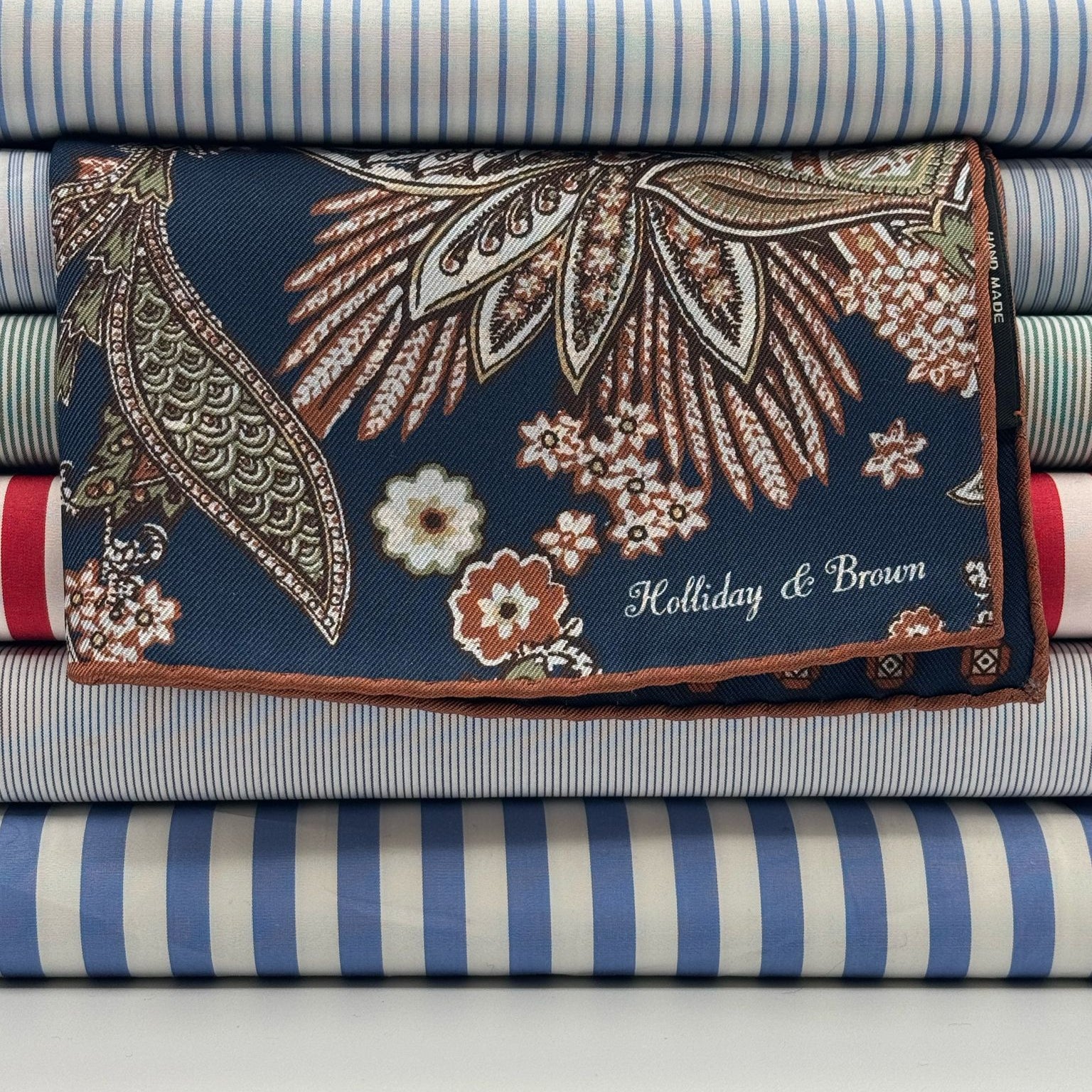 Holliday &amp; Brown
Hand-rolled&nbsp;&nbsp;
Holliday &amp; Brown for Cruciani &amp; Bella
100% Silk
Blue, Off White, Green and Brown
Double Faces
Paisley Motif&nbsp; Pocket Square
Handmade in Italy

32 cm X 32 cm