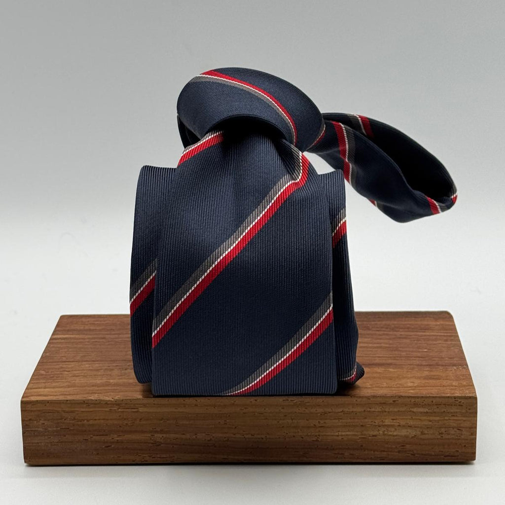 Cruciani &amp; Bella
100% Woven Silk&nbsp;

Crazy Regimental Tie
Tipped&nbsp;
Blue, Grey, Red and White Stripes

Handmade in Italy
8,5 cm x 148 cm
New Old Stock